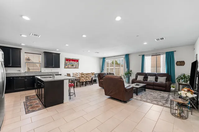 a living room with furniture kitchen view and a window