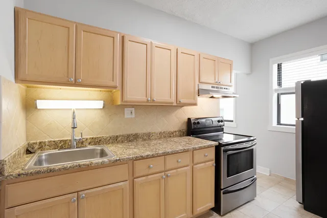 a kitchen with granite countertop cabinets stainless steel appliances and a sink