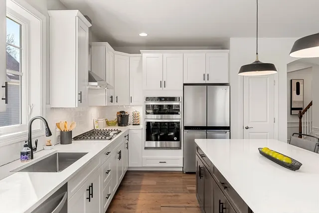 a kitchen with kitchen island granite countertop a sink a counter space and cabinets