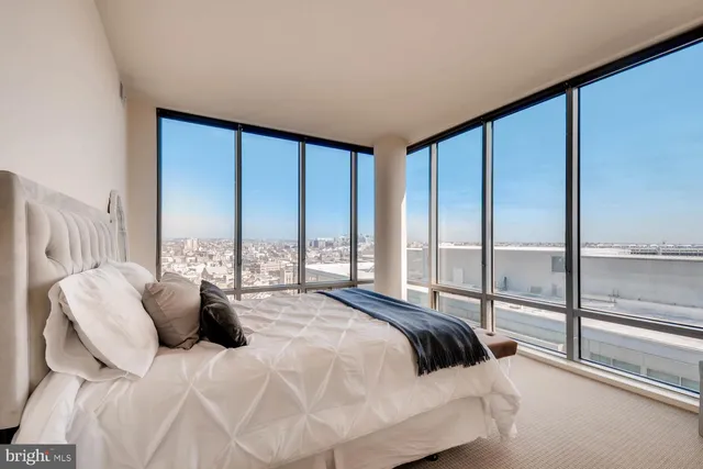 a large bed sitting in a bedroom next to a large window