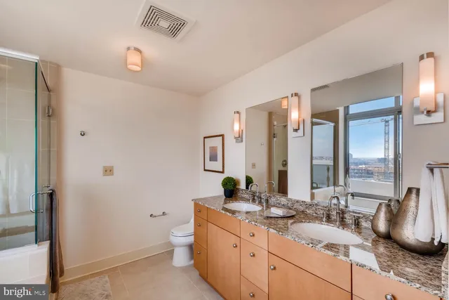 a bathroom with a granite countertop sink double and mirror