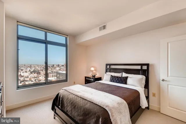 a bedroom with a large bed and a large window