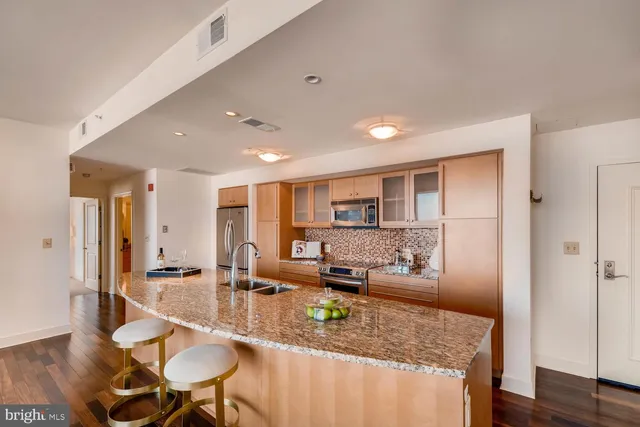 a kitchen with stainless steel appliances granite countertop a sink refrigerator and cabinets