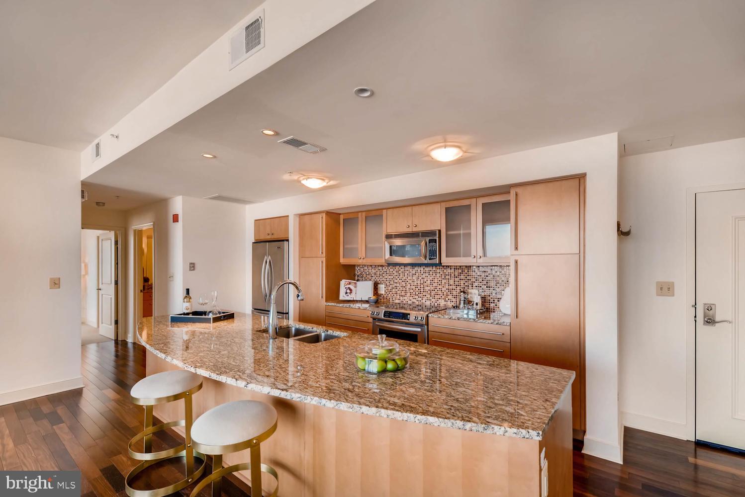 675 President Street, Unit 1806 Baltimore, MD 21202 - Photo 8 of 46 a kitchen with stainless steel appliances granite countertop a sink refrigerator and cabinets