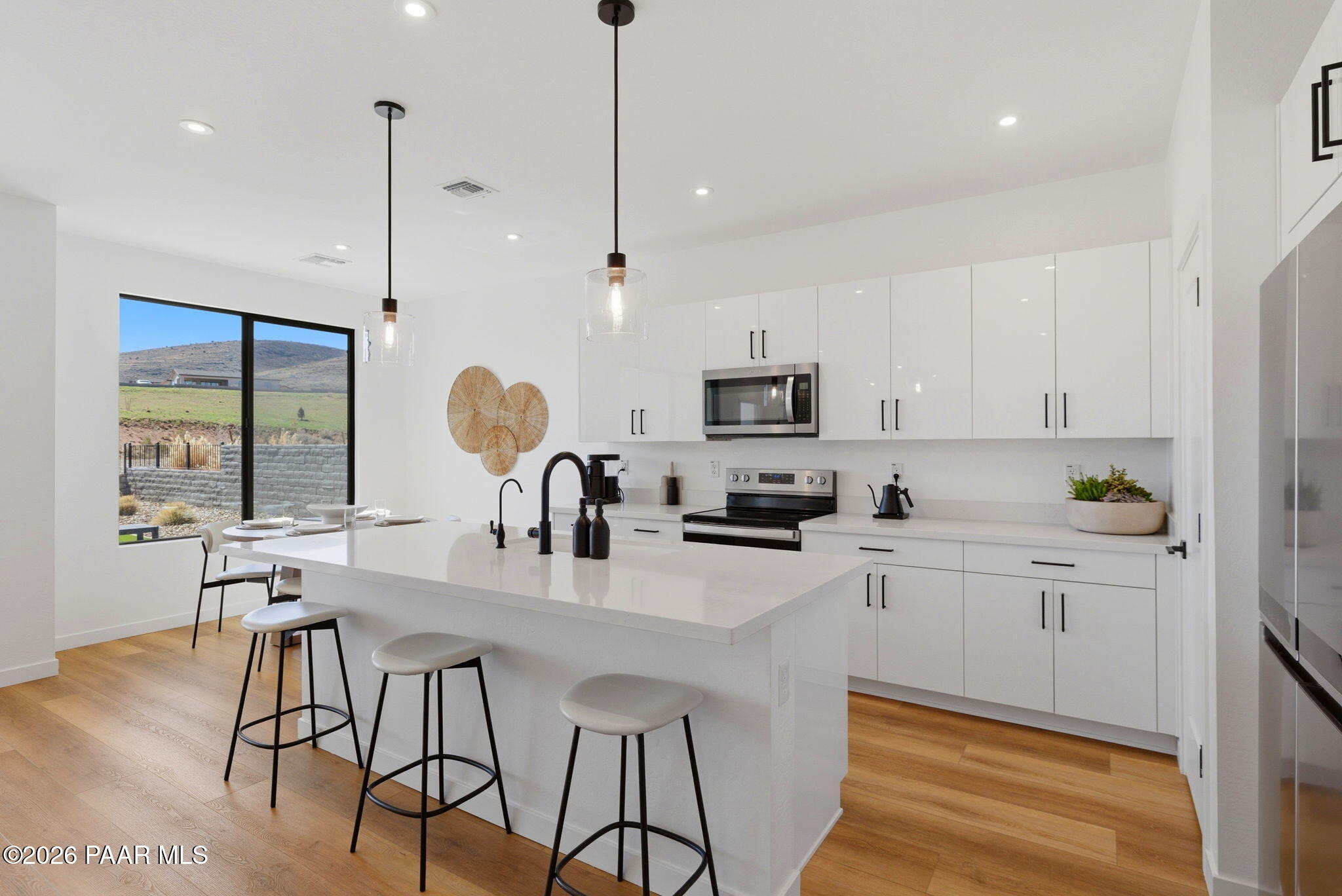 5994 East Killen Loop Prescott Valley, AZ 86314 - Photo 8 of 119 a kitchen with stainless steel appliances a stove a sink a center island a refrigerator and a wooden floor
