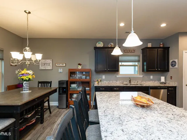 a kitchen with stainless steel appliances granite countertop a sink a stove and a wooden floors