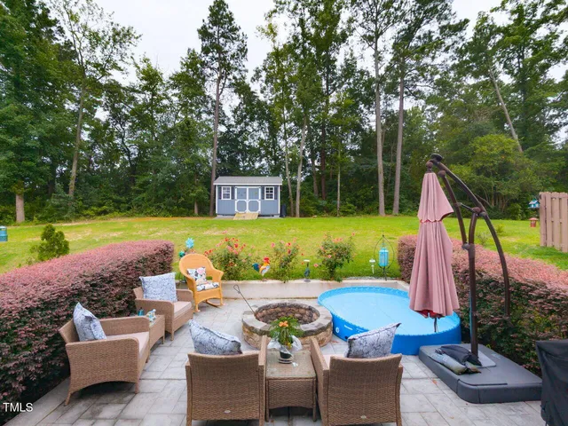 a view of a backyard with swimming pool and furniture