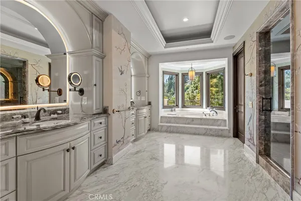a spacious bathroom with a double vanity sink a large mirror and a bathtub