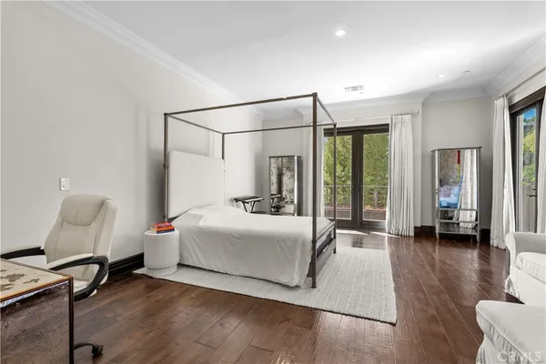 a bedroom with a bed large window and a mirror
