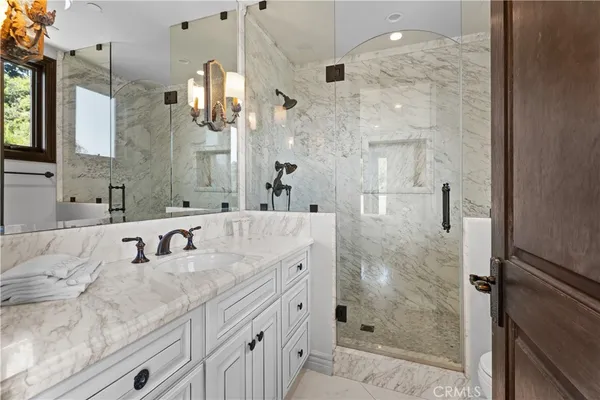 a bathroom with a double vanity sink mirror and shower