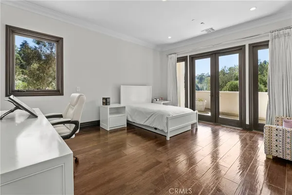 a bedroom with a bed and large windows