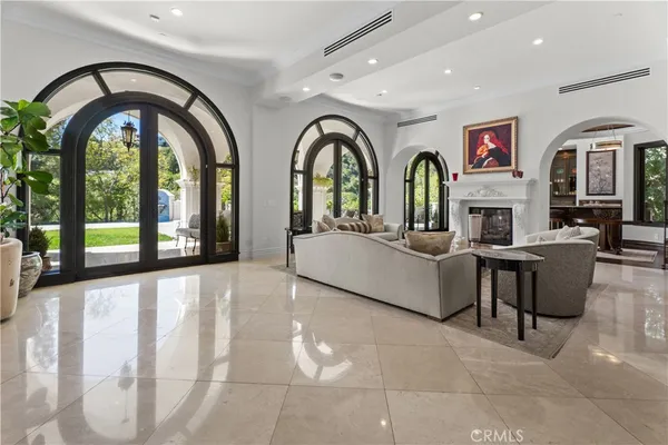 a living room with fireplace furniture and large windows