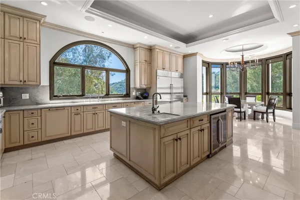 a kitchen with sink a stove and chairs