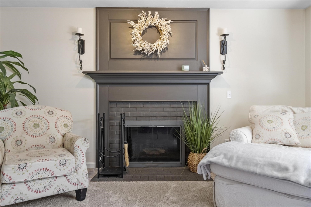 4 Ridge Road Pepperell, MA 01463 - Photo 18 of 42 a living room with a couch a fireplace and a potted plant