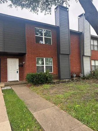 a view of a brick house with a yard