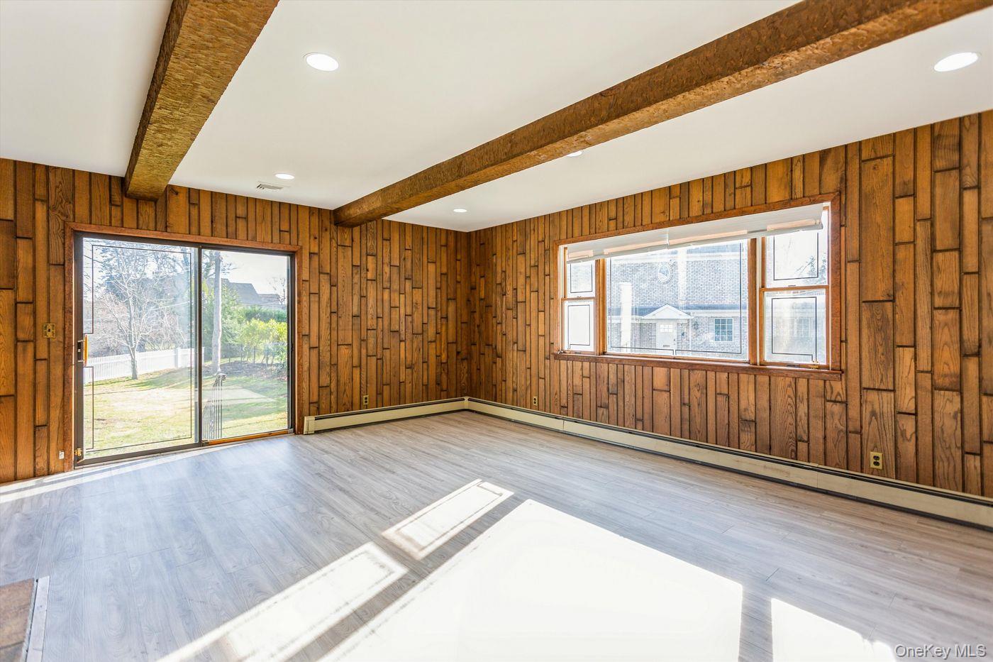 1 Sutton Place Lawrence, NY 11559 - Photo 12 of 38 a view of an empty room with wooden floor and a window
