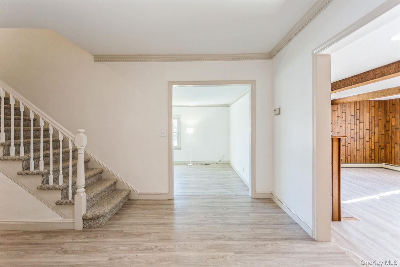 1 Sutton Place Lawrence, NY 11559 - Photo 15 of 38 a view of a hallway with wooden floor and staircase