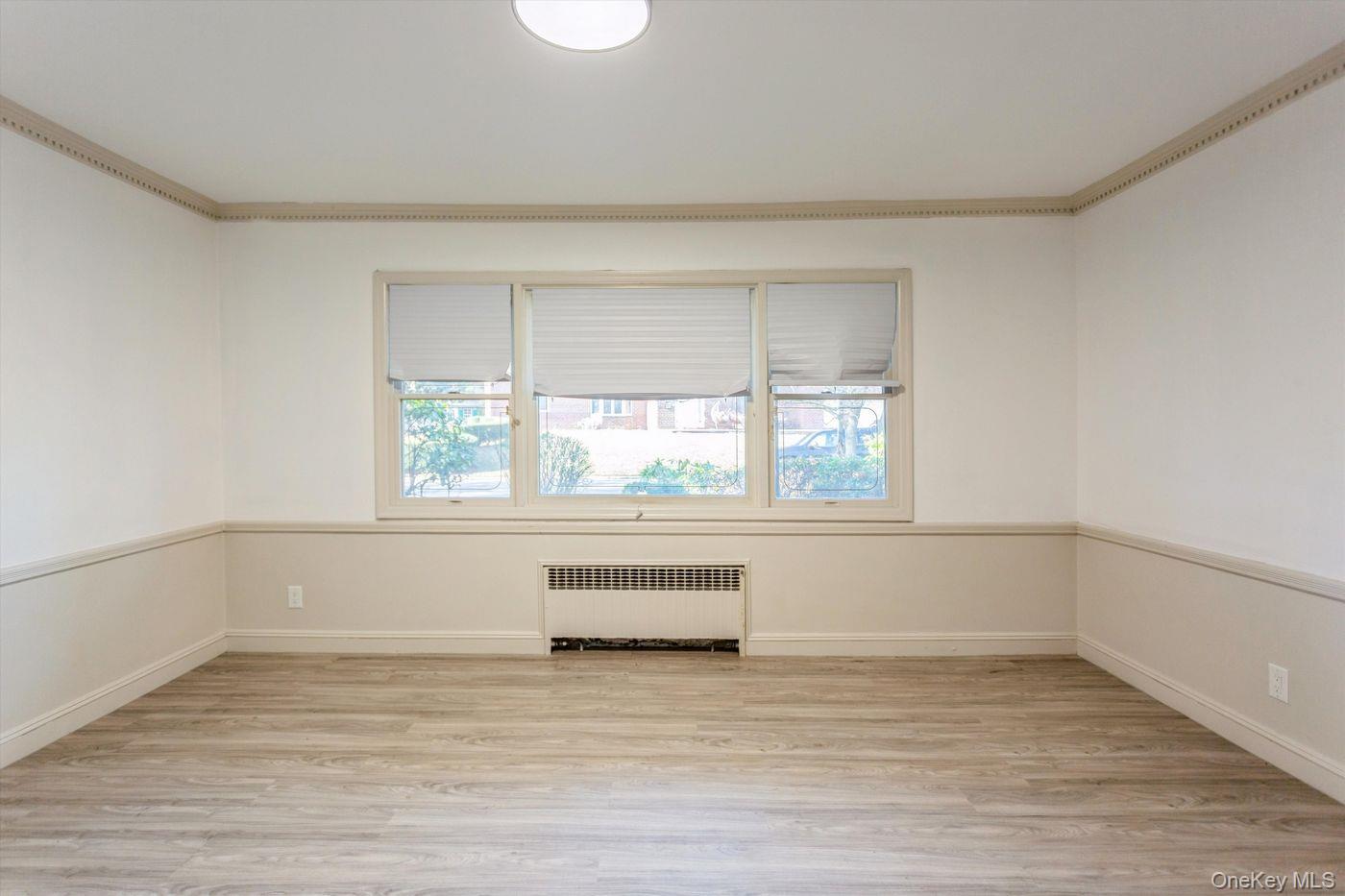 1 Sutton Place Lawrence, NY 11559 - Photo 17 of 38 a view of an empty room with wooden floor and a window