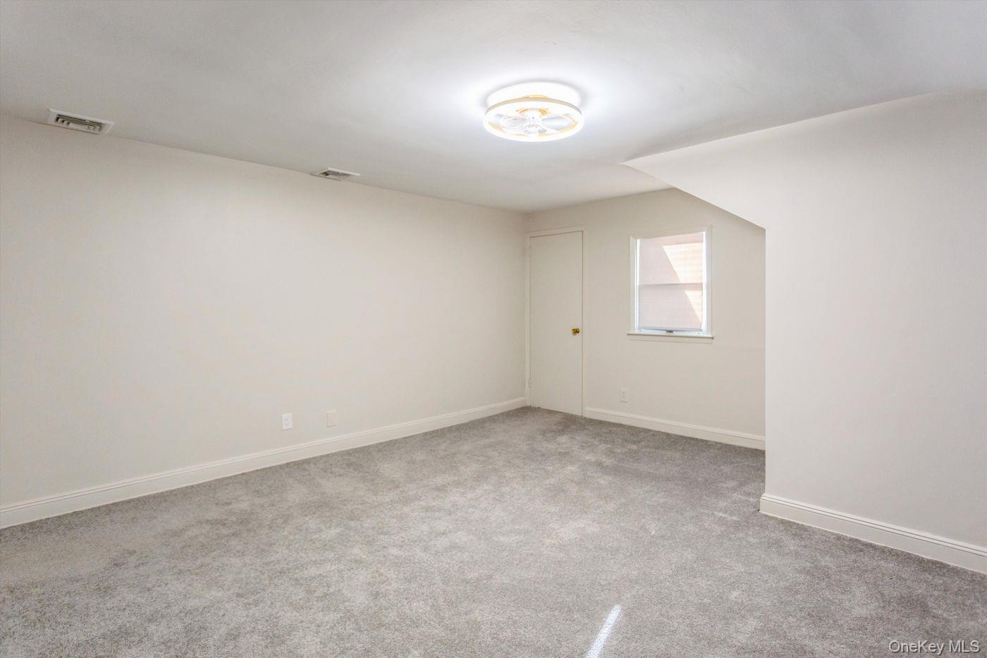 1 Sutton Place Lawrence, NY 11559 - Photo 19 of 38 Empty room with light carpet and baseboards