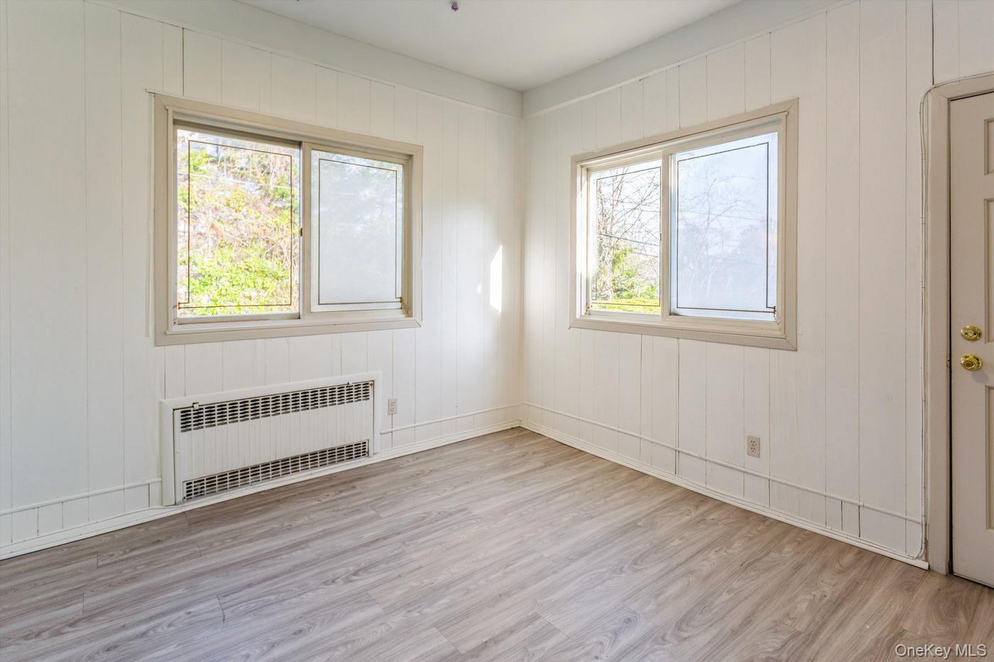 1 Sutton Place Lawrence, NY 11559 - Photo 23 of 38 an empty room with wooden floor and windows