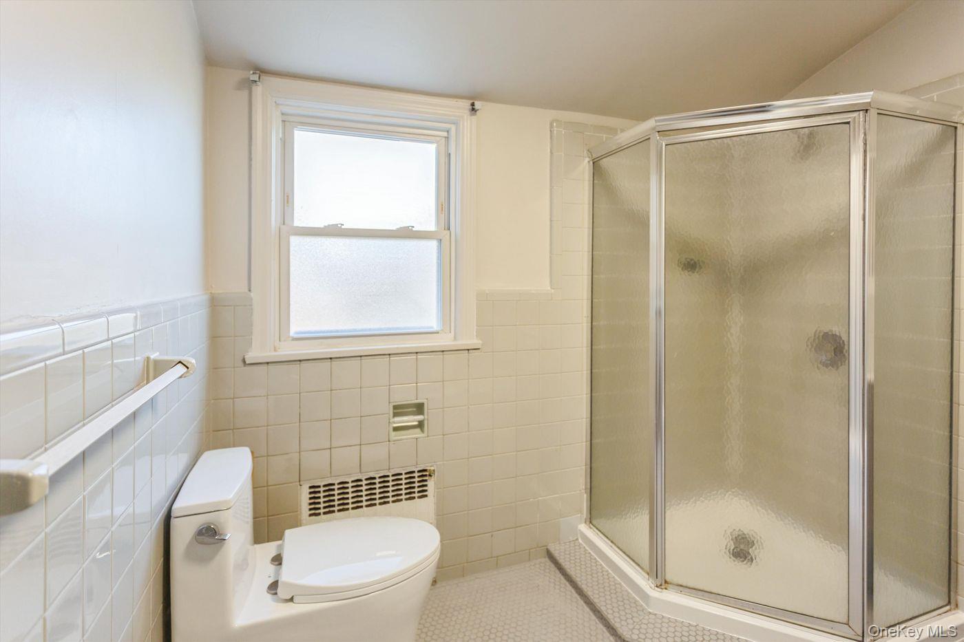 1 Sutton Place Lawrence, NY 11559 - Photo 24 of 38 a bathroom with a shower a toilet and a sink
