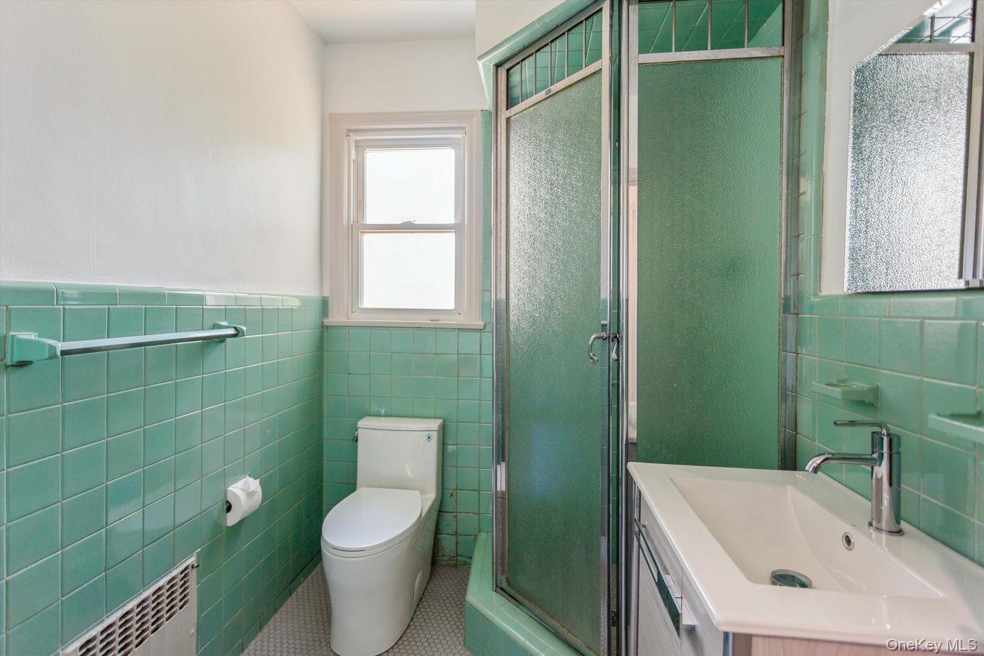 1 Sutton Place Lawrence, NY 11559 - Photo 25 of 38 a bathroom with a sink a toilet and a mirror