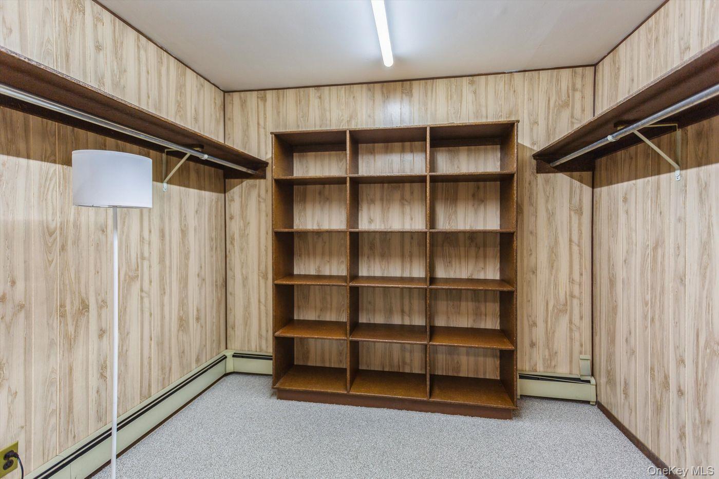 1 Sutton Place Lawrence, NY 11559 - Photo 29 of 38 Walk in closet featuring light colored carpet and a baseboard radiator