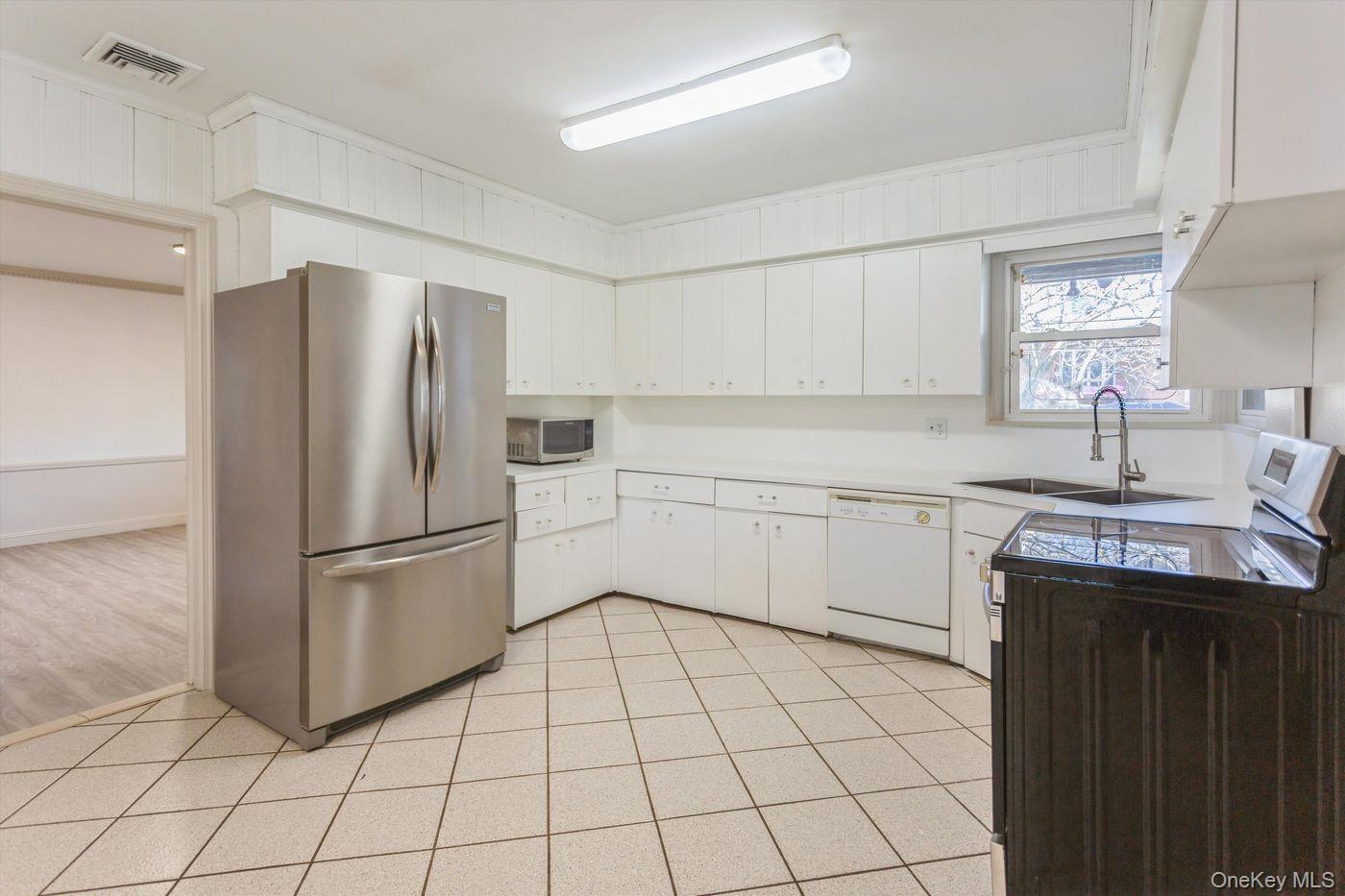 1 Sutton Place Lawrence, NY 11559 - Photo 6 of 38 a kitchen with a refrigerator sink and cabinets