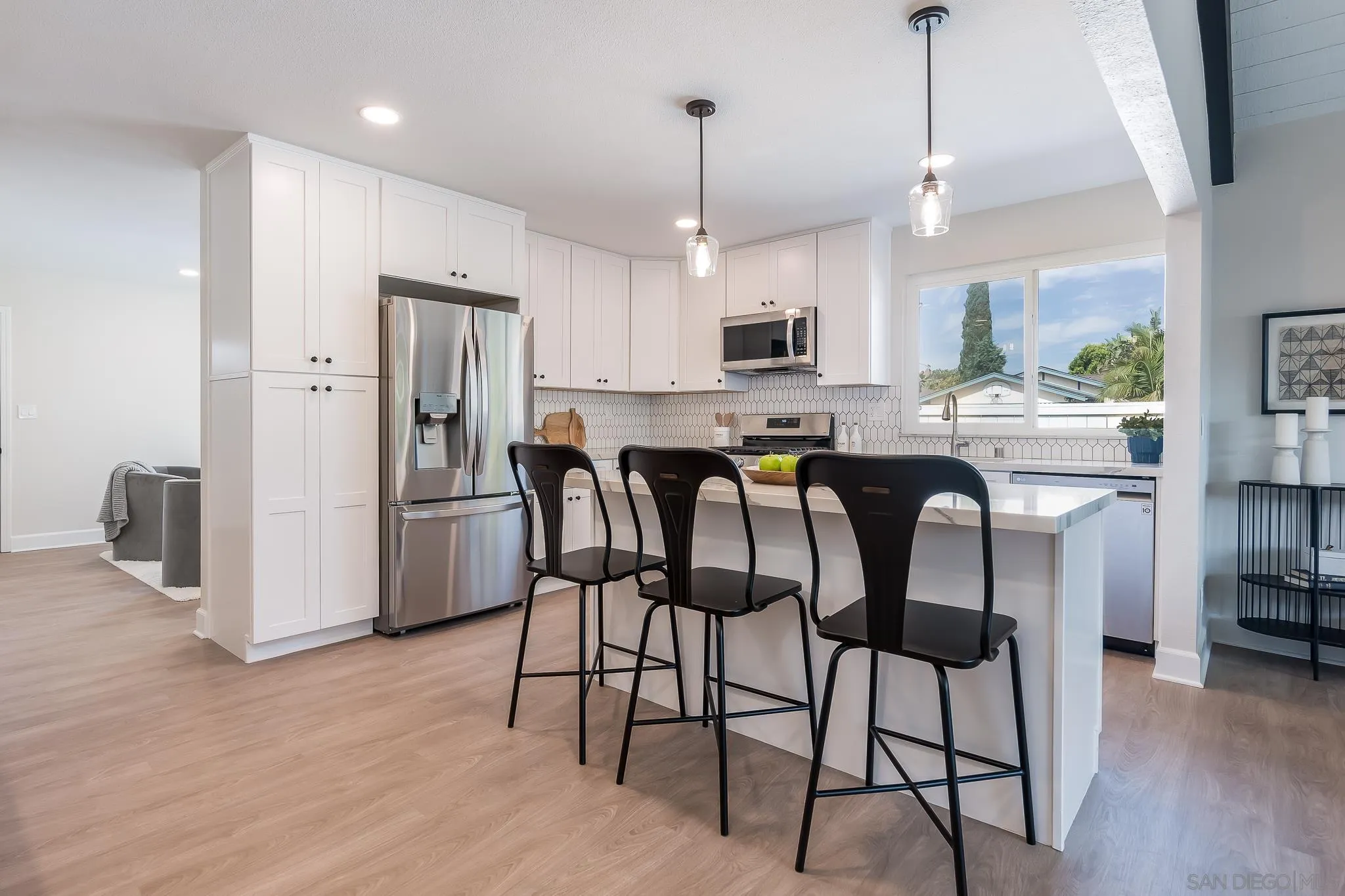 8510 Lepus Road San Diego, CA 92126 - Photo 11 of 35 a kitchen with stainless steel appliances a dining table chairs refrigerator and microwave