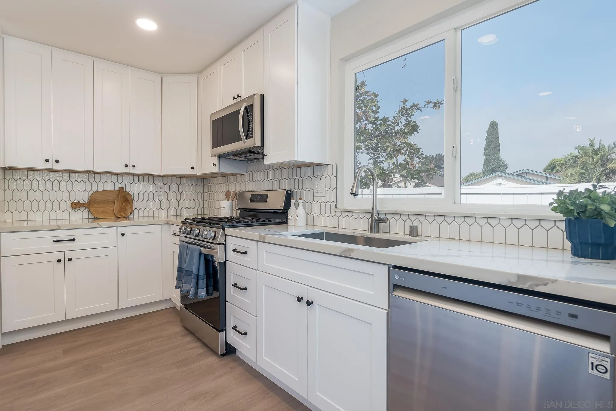 8510 Lepus Road San Diego, CA 92126 - Photo 13 of 35 a kitchen with granite countertop white cabinets and white stainless steel appliances