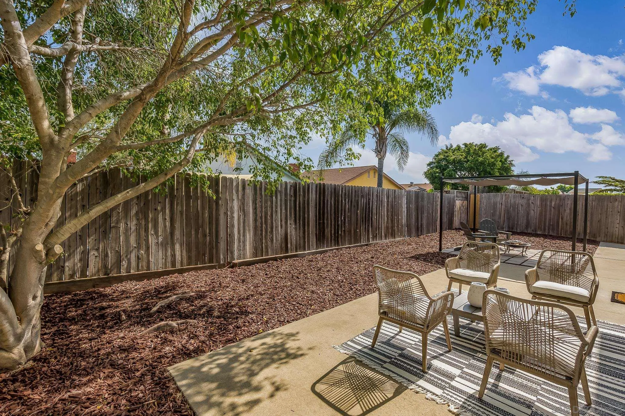 8510 Lepus Road San Diego, CA 92126 - Photo 27 of 35 a view of backyard with table and chairs with wooden fence