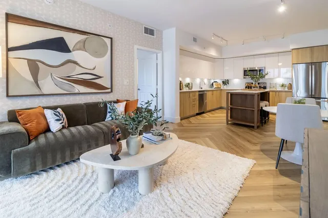a living room with furniture and kitchen view