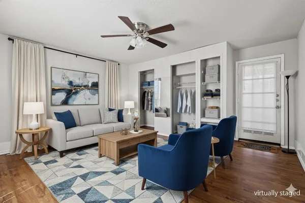 a living room with furniture ceiling fan and a wooden floor