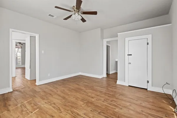 a view of empty room with wooden floor