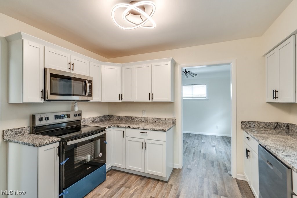 6961 Maplewood Road Parma Heights, OH 44130 - Photo 5 of 22 Kitchen with light hardwood / wood-style floors, white cabinetry, and stainless steel appliances