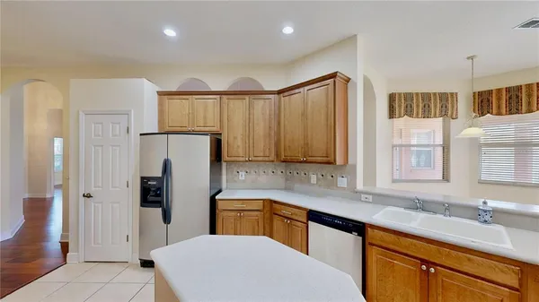a kitchen with a sink refrigerator and cabinets