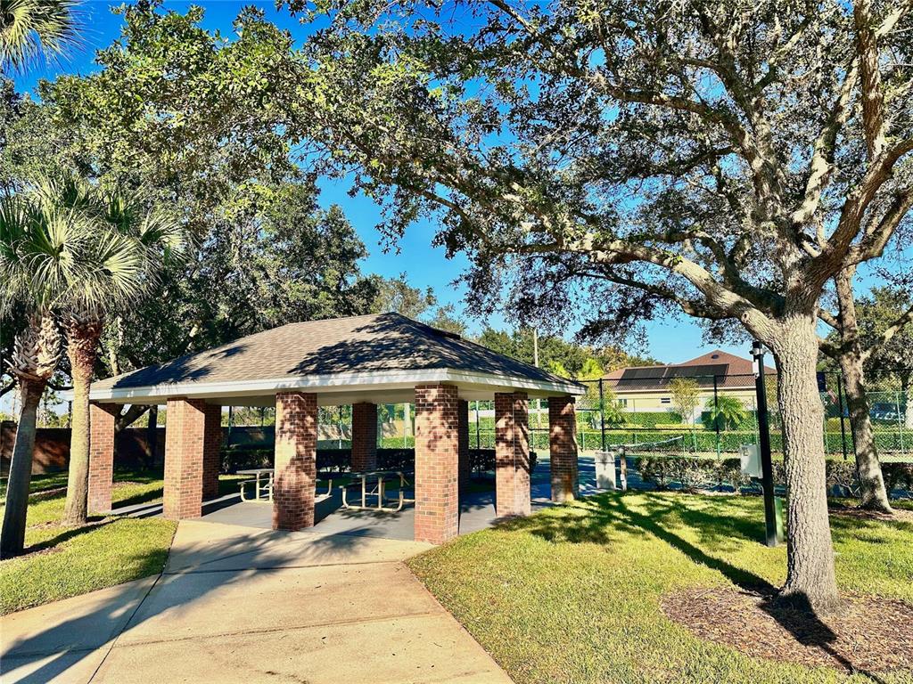 586 Huntington Pines Drive Ocoee, FL 34761 - Photo 50 of 51 a view of a patio with table and chairs under an umbrella