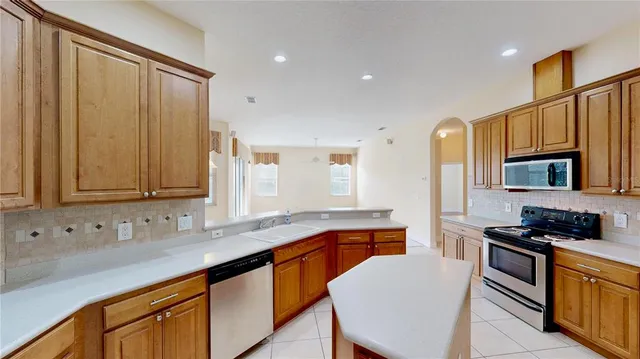 a kitchen with stainless steel appliances granite countertop a sink stove and cabinets