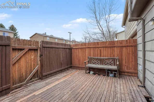a view of an empty room with wooden floor fireplace and a window