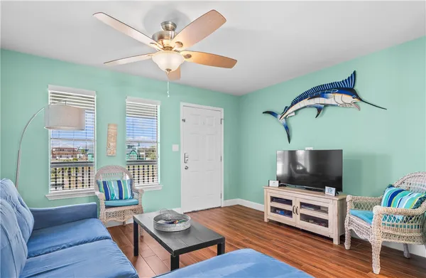 a living room with furniture a flat screen tv and a window