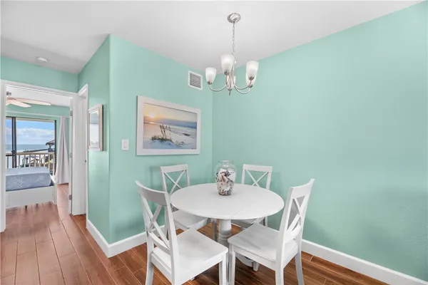 a view of a dining room with furniture wooden floor and a chandelier