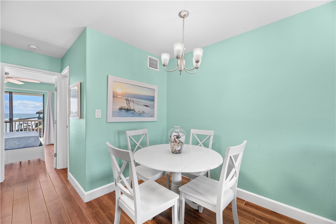 2290 North Fulton Beach Road, Unit 212 Rockport, TX 78382 - Photo 10 of 19 a view of a dining room with furniture wooden floor and a chandelier