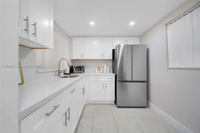 a kitchen with a refrigerator sink and cabinets