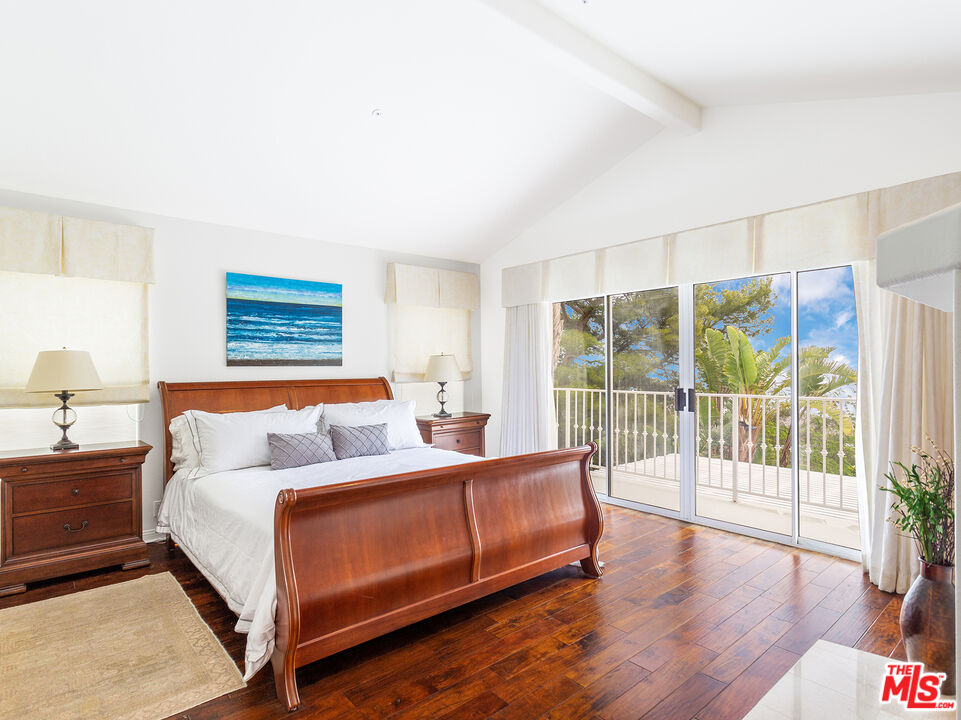 4324 Hillview Drive Malibu, CA 90265 - Photo 16 of 24 a bedroom with a balcony a bed and a large window