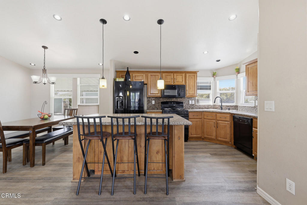 1657 Lime Avenue, Unit 87 Oxnard, CA 93033 - Photo 12 of 37 a kitchen with stainless steel appliances kitchen island granite countertop a table chairs sink and cabinets