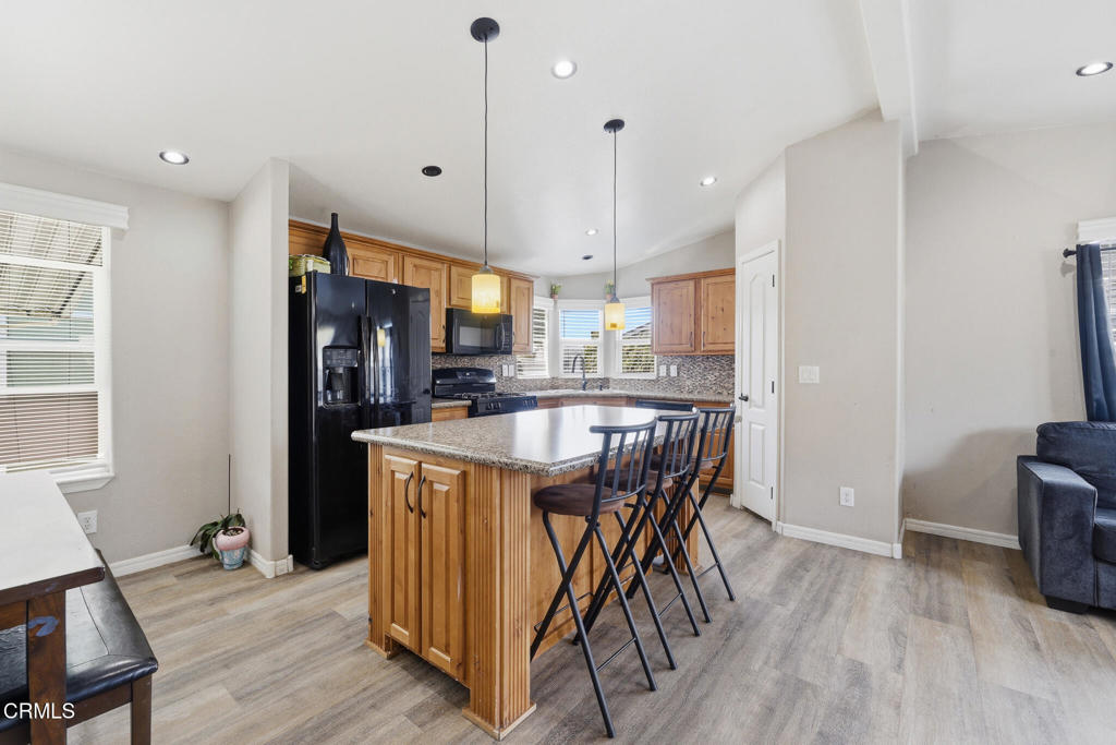 1657 Lime Avenue, Unit 87 Oxnard, CA 93033 - Photo 13 of 37 a kitchen with stainless steel appliances granite countertop a refrigerator a stove top oven a sink dishwasher and white cabinets with wooden floor