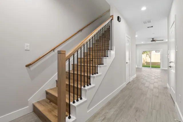 a kitchen with stainless steel appliances granite countertop a sink a refrigerator a stove a kitchen island with wooden floor