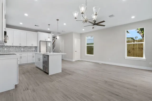 a view of a kitchen with a refrigerator a microwave and a stove top oven