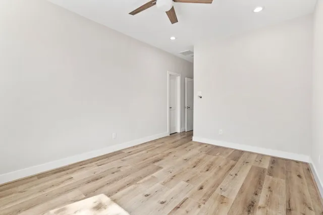 a view of an empty room with wooden floor
