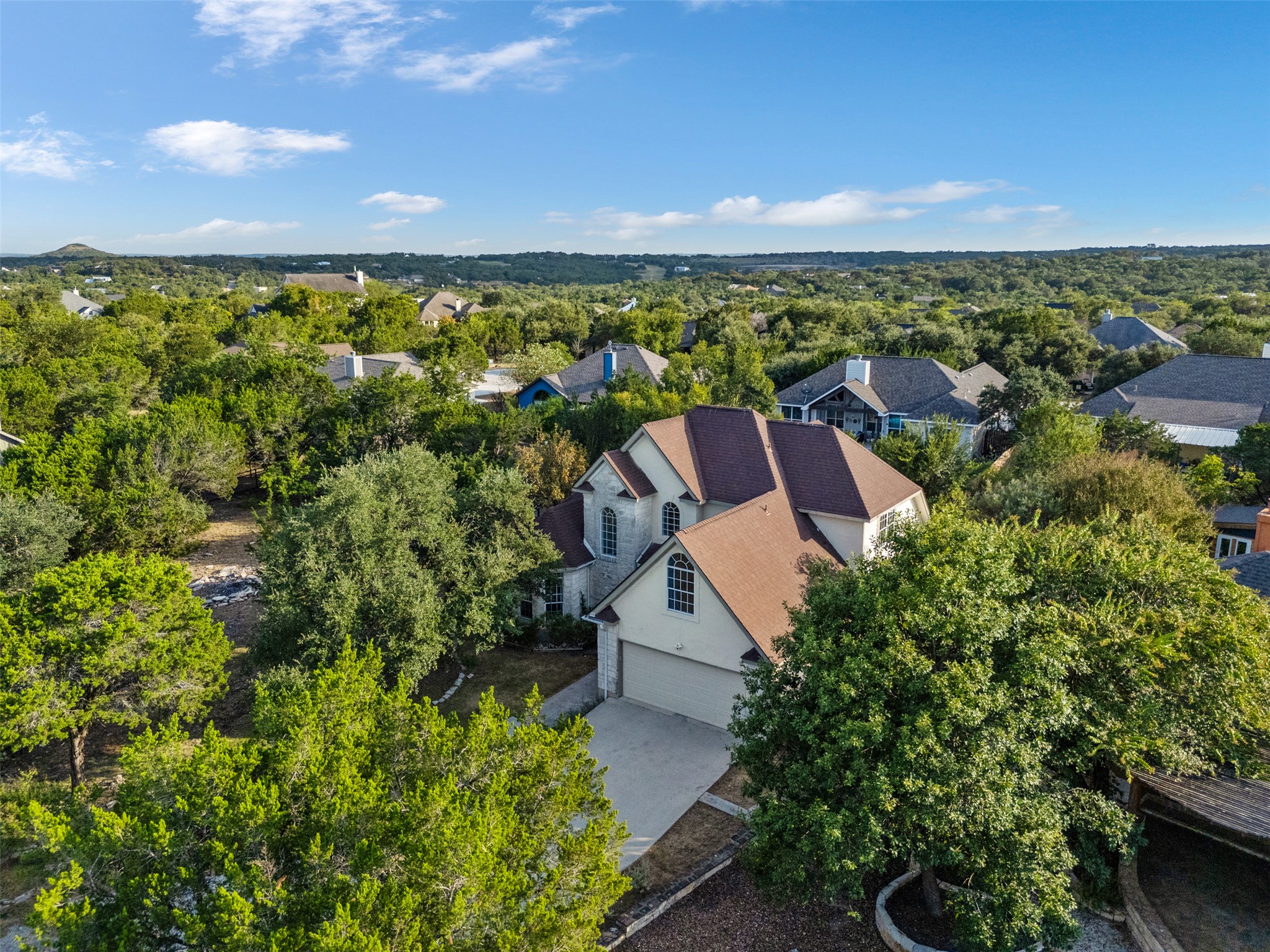 72 Crazy Cross Road Wimberley, TX 78676 - Photo 33 of 35 Lush mature trees surround this multi-story residence nestled within a rolling hillside neighborhood.